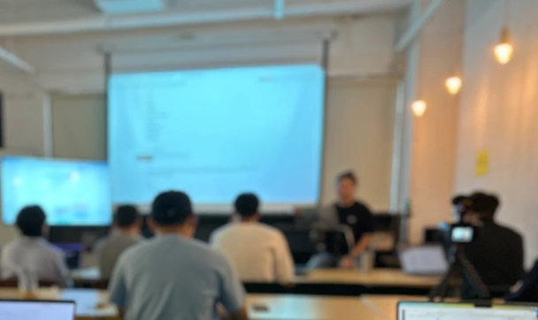expertLABS 교육 현장 — 수강생들이 노트북을 펴고 스크린의 실습 화면을 따라 실습하고 있다